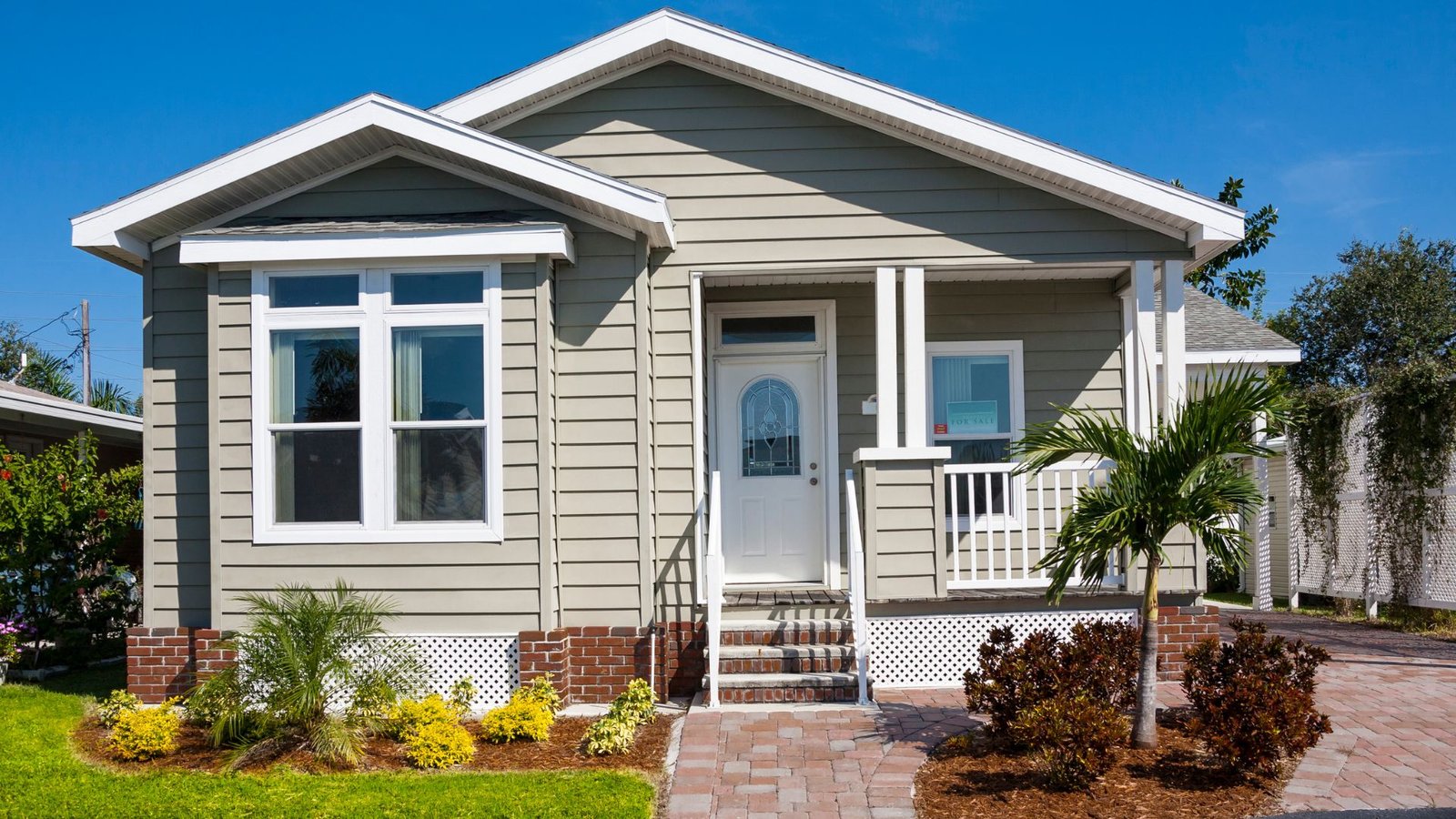 Tankless water heater home featuring modern green landscaping and stylish architectural design.