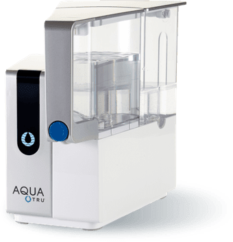 Countertop reverse osmosis system AquaTru with sleek white design and transparent water reservoir.