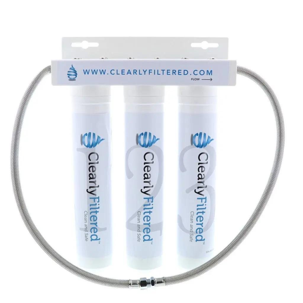 Fluoride water filter by Clearly Filtered featuring three white cylindrical cartridges and durable metallic hose.