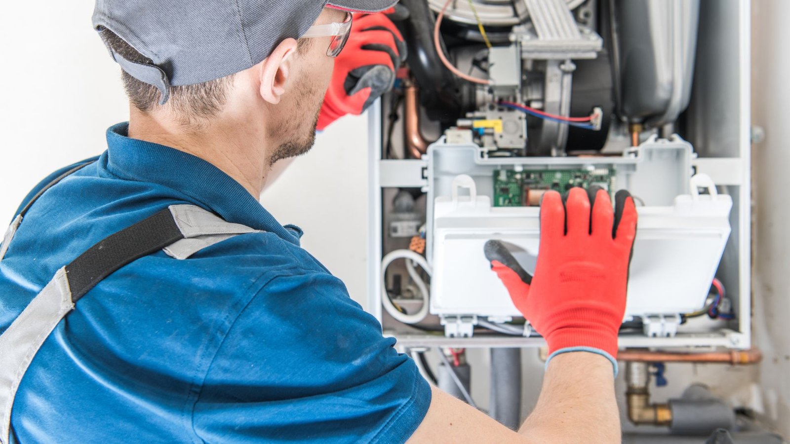 Gas Vs Electric Tankless Water Heaters Technician working diligently on HVAC system maintenance.